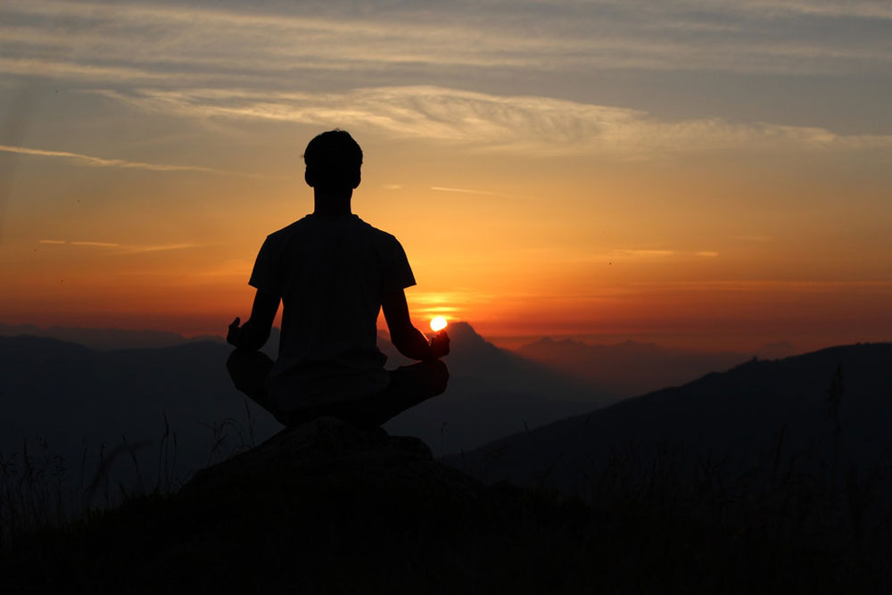 Un uomo che fa Yoga al tramonto